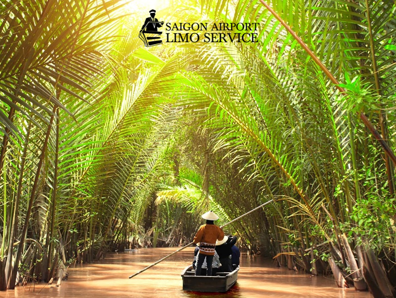 Saigon Airport Limo Tours Traditional boat navigating the Mekong Delta river amidst lush greenery, representing a scenic day tour from Ho Chi Minh City, Vietnam.
