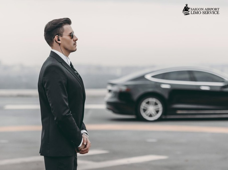 Saigon Airport Limo: Executive Protection & Security Transfers Professional executive protection agent with earpiece guarding a luxury vehicle for Saigon Airport Limo's security service in Vietnam.